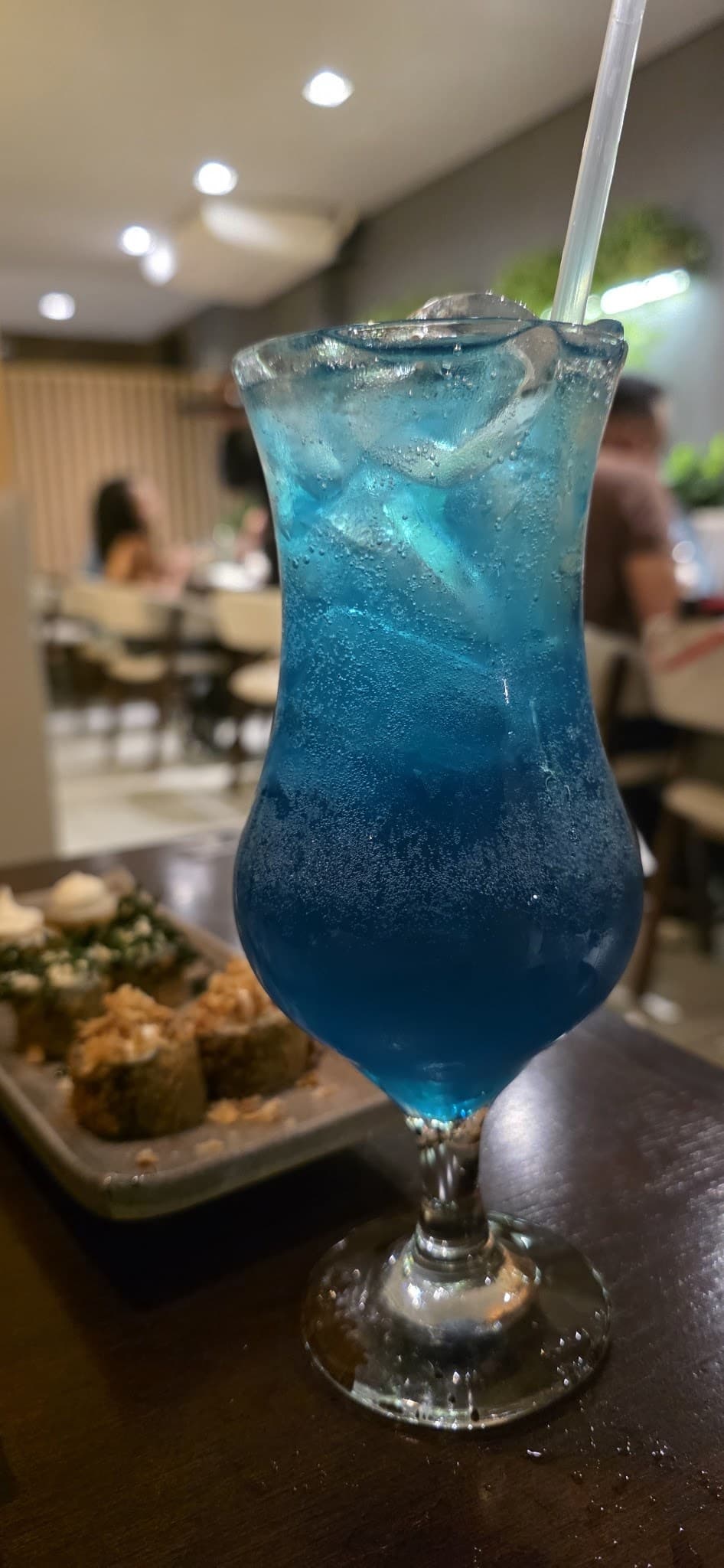 Drink azul com limão numa taça alta